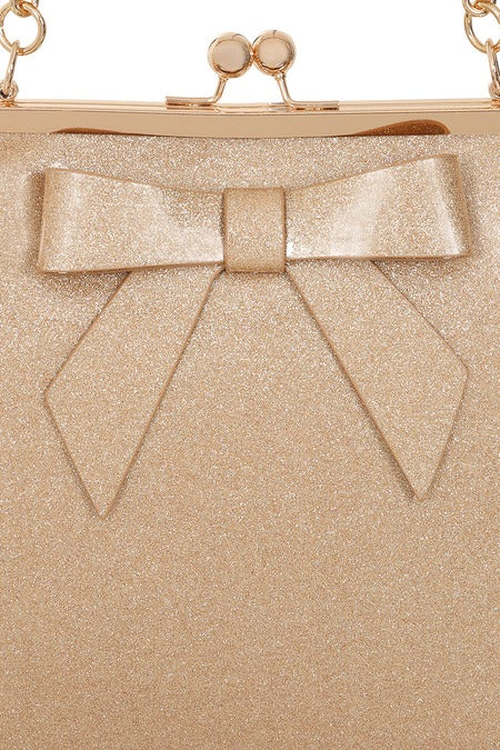 Gold glittery clutch bag with a large bow detail on a white background