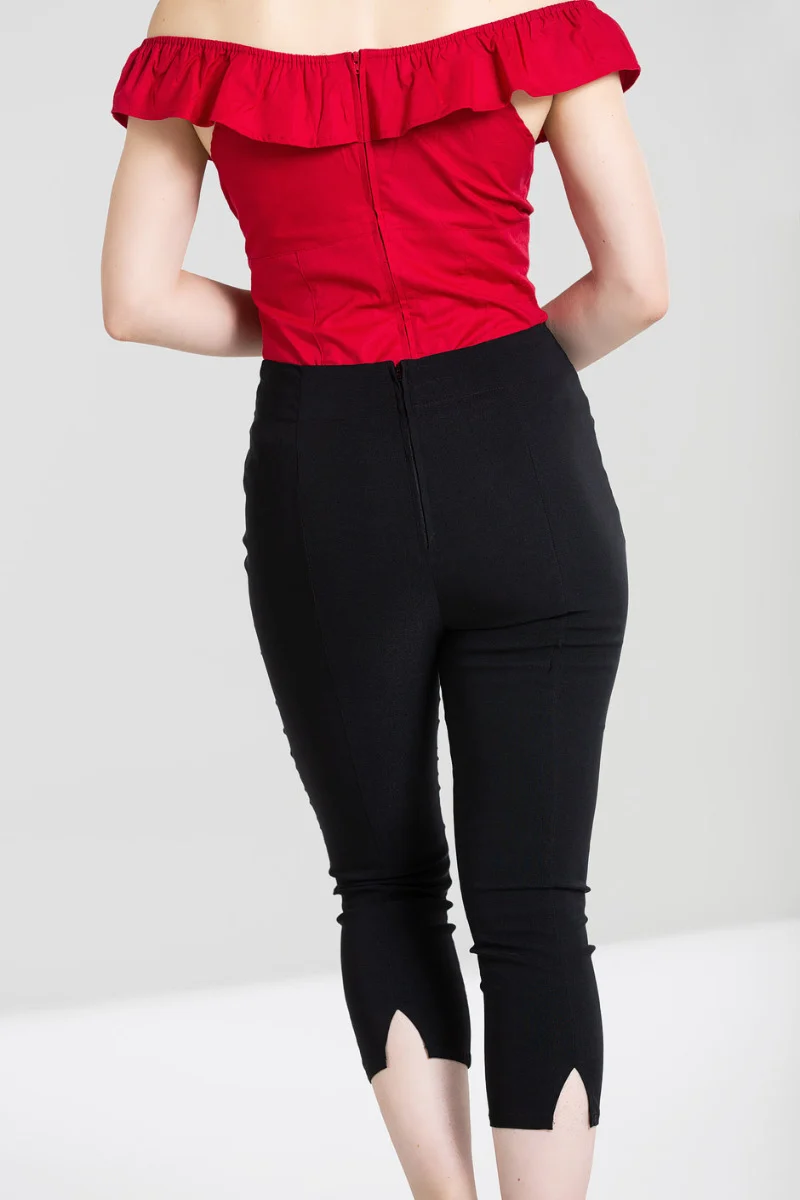 Person wearing a red off-shoulder top and black high-waisted pants on a white background