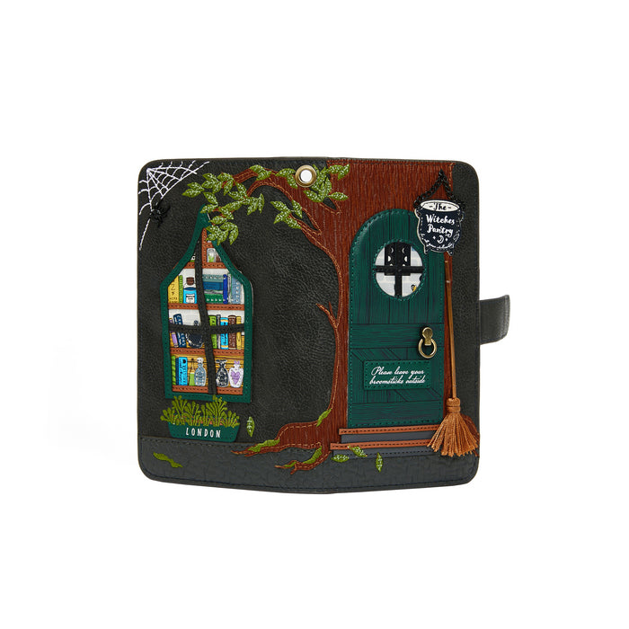 Handbag with treehouse design featuring a door, window, and broomstick on a white background