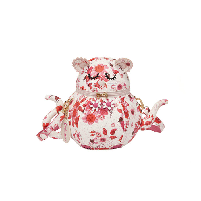 Floral-patterned teapot with pig design on a white background