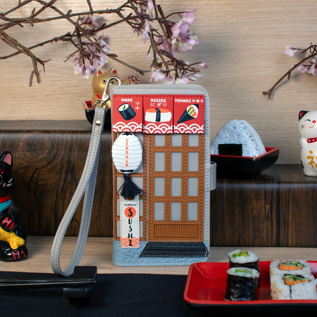 Phone case with sushi design and cherry blossoms in the background