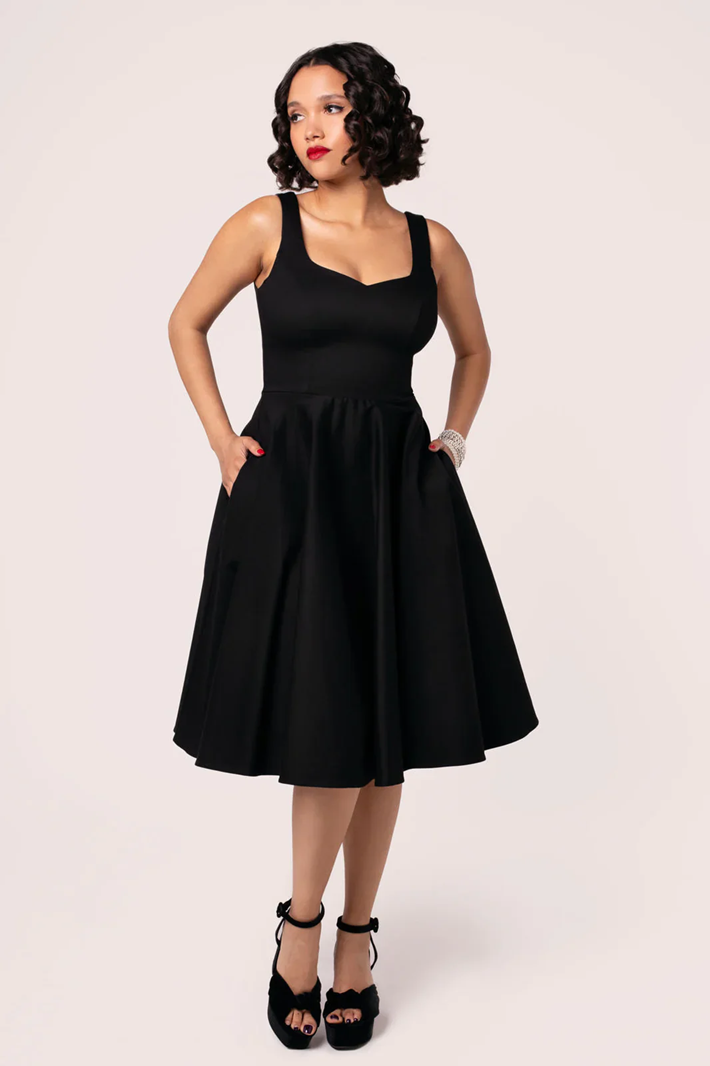 Woman wearing a black dress against a white background