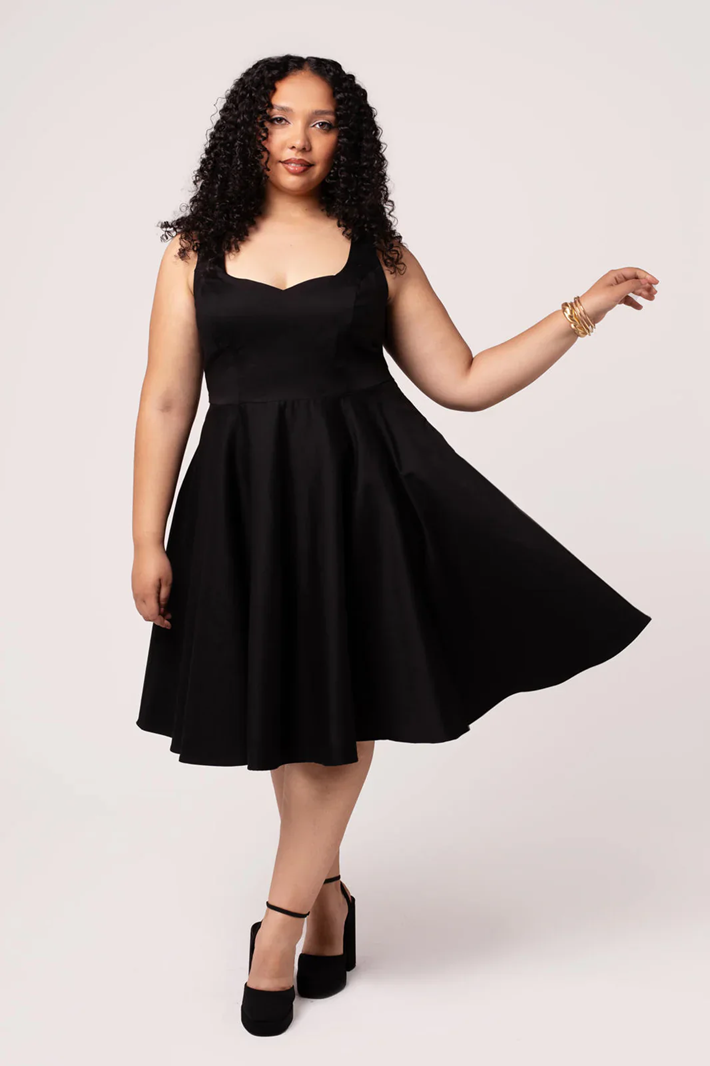 Woman wearing a black dress against a white background