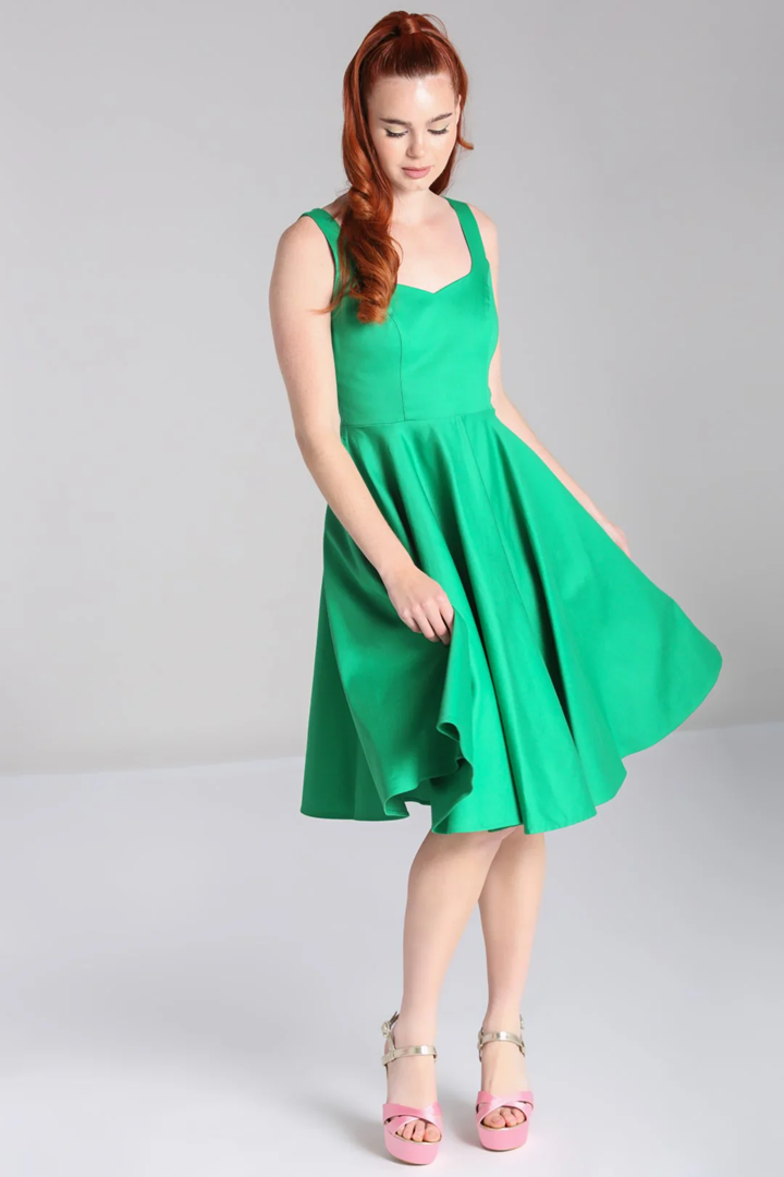 Woman wearing a green dress on a plain background