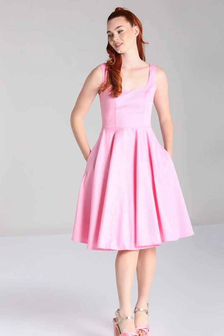 Woman wearing a pink dress against a gray background