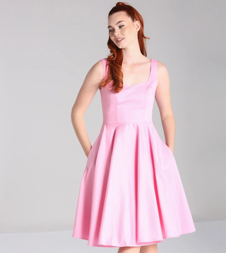 Woman wearing a pink dress against a gray background