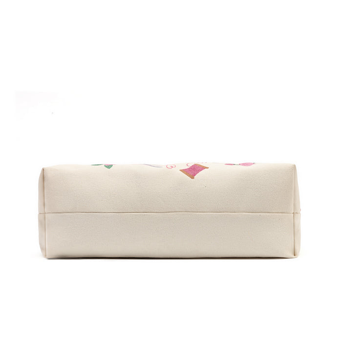 A cream-colored canvas pouch with a subtle pink and green floral pattern on the top, shown against a plain white background.