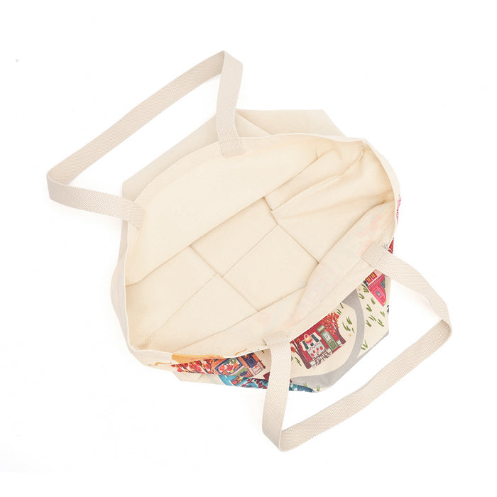 A cream-colored canvas tote bag with a colorful patterned bottom panel and matching cream shoulder straps, shown from a top-down view on a white background.
