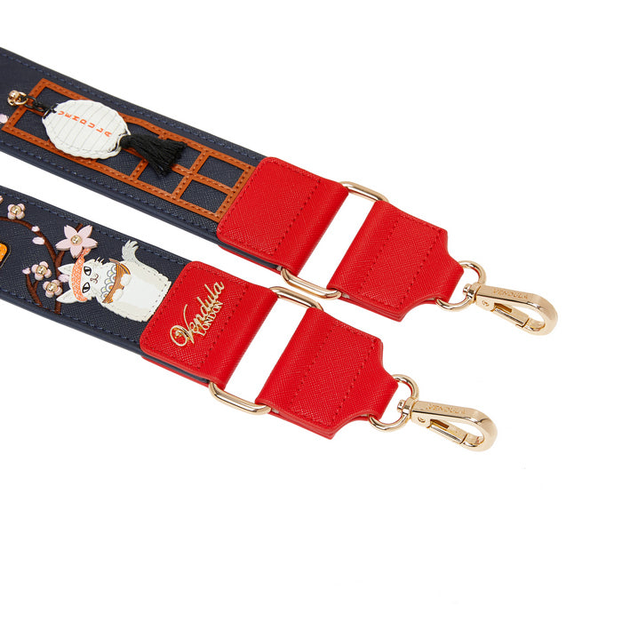 Close-up of a strap with red buckle and gold hardware on a white background