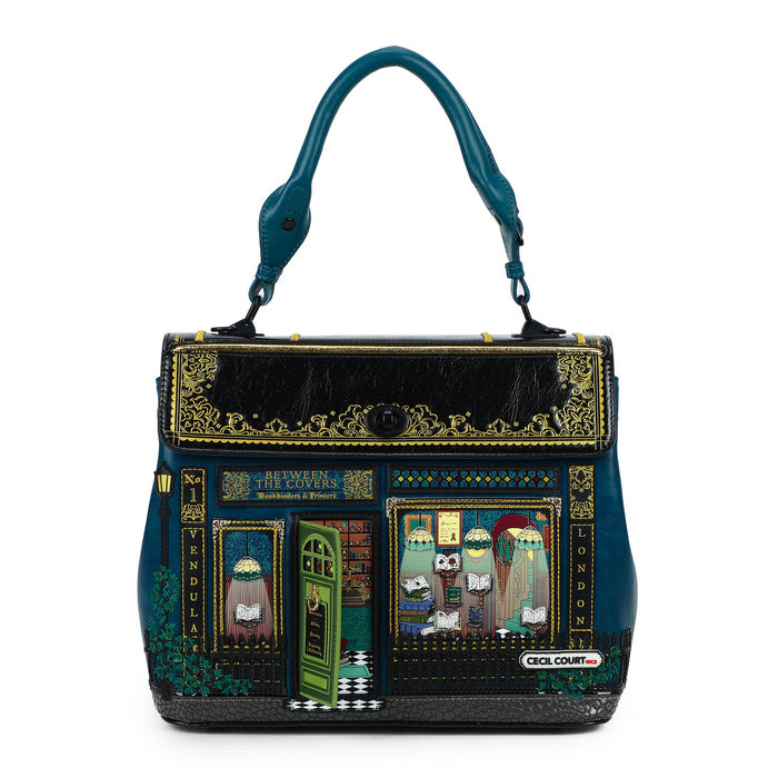 Decorative handbag with intricate designs and a teal handle on a white background