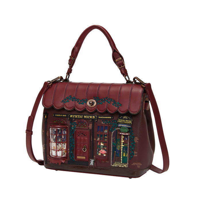 Brown leather handbag with decorative design on a white background