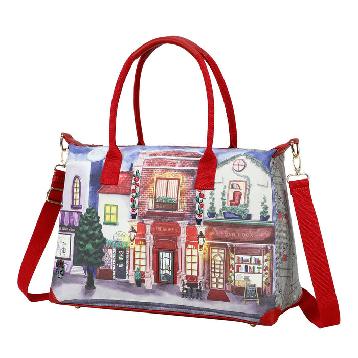 Handbag with a street scene design and red handles and strap on a white background