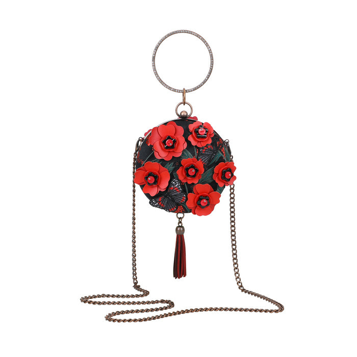 Round bag with red floral design and tassel on a white background