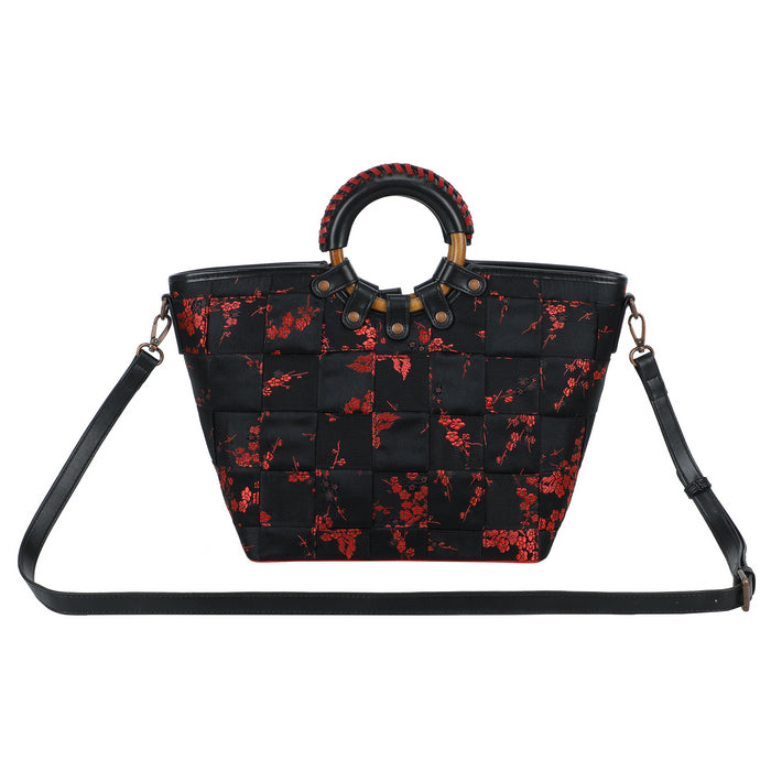 Black handbag with red floral pattern on a white background