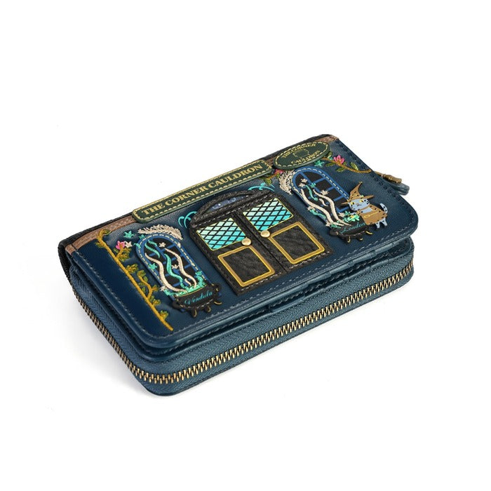 A dark teal zip-around wallet featuring a highly detailed, colorful embroidered patch of a gothic-style door labeled 'The Corset Catacombs' on the front, set against a plain white background.