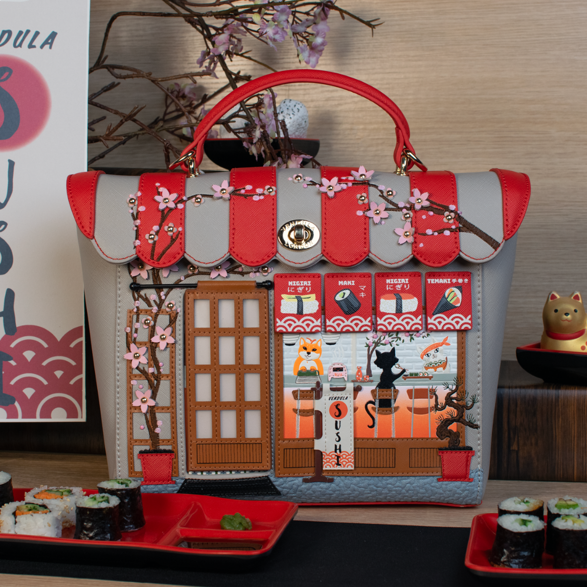 Handbag with sushi restaurant design and cherry blossoms, placed on a table with sushi.