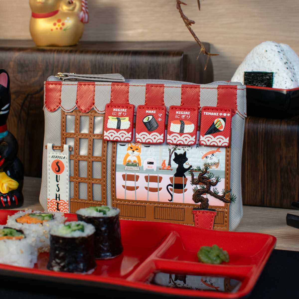 Sushi-themed pouch with cartoon characters on a table with sushi and chopsticks.