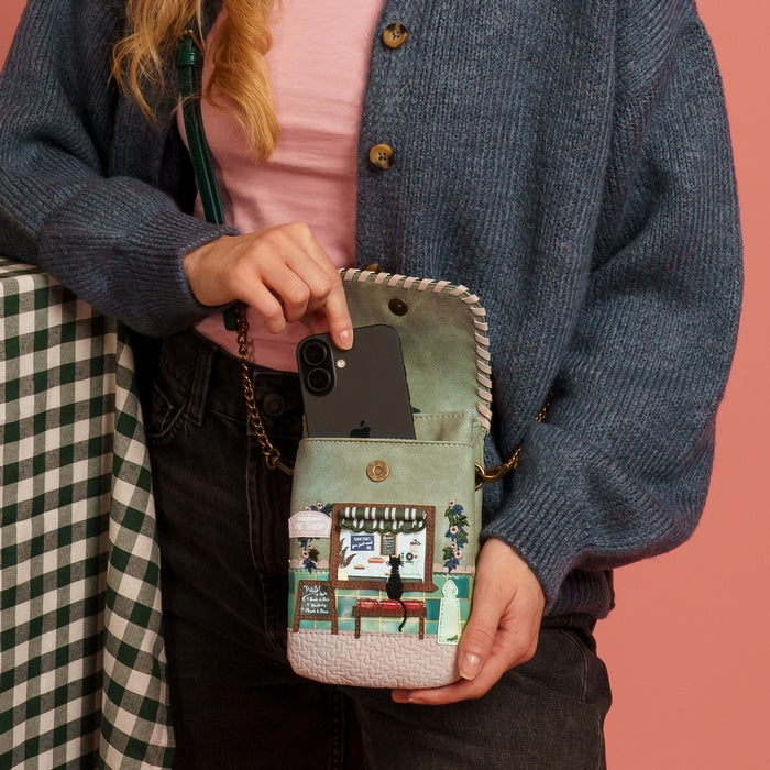 Person holding a phone case with a colorful design against a pink background