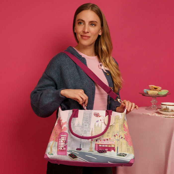 Woman holding a patterned bag with a pink background