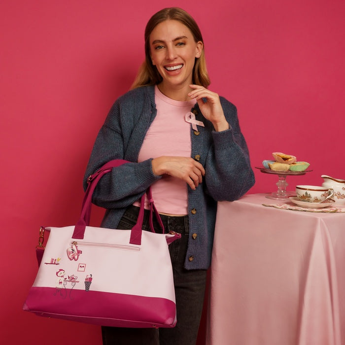 Woman holding a pink and white tote bag with a pink background