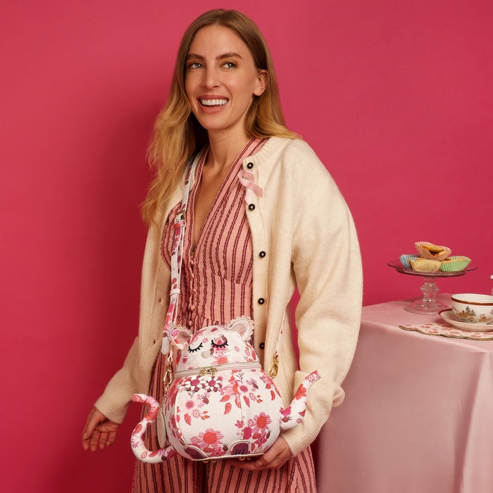 Woman holding a floral-patterned bag with a pink background