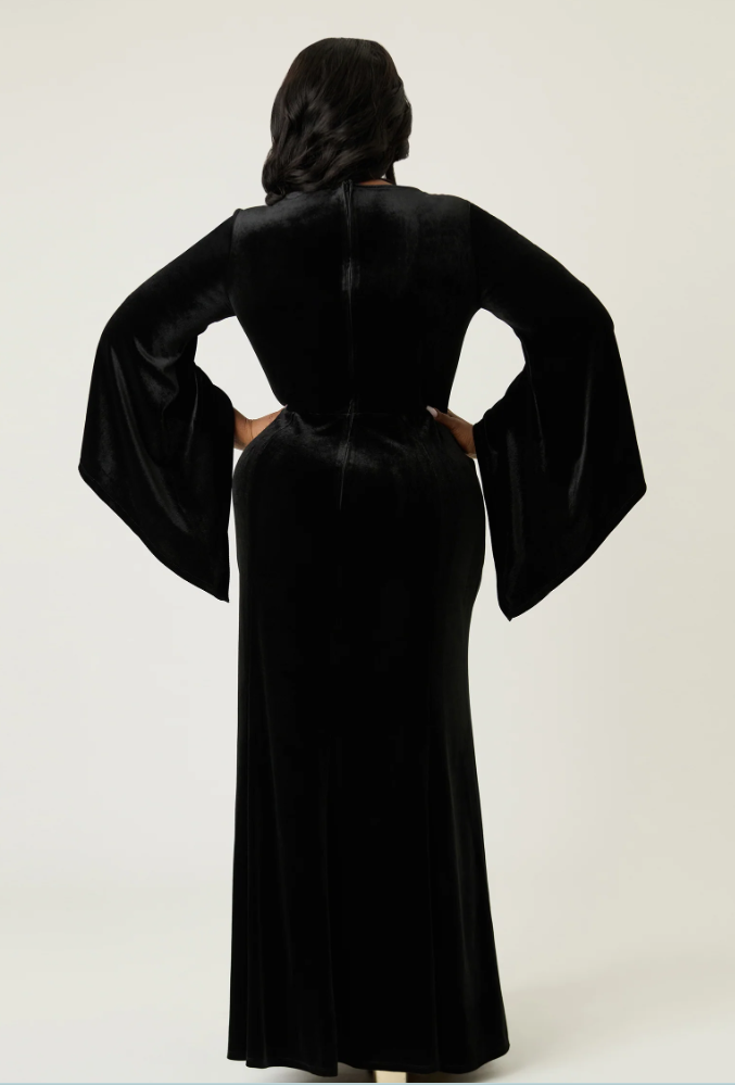 Person wearing a black abaya with wide sleeves on a white background