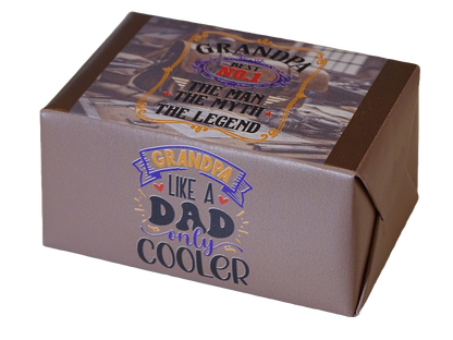 A square gift box with a metallic taupe-gray exterior and a printed top label. The front reads 'GRANDPA LIKE A DAD only COOLER' in stylized blue, purple, and yellow lettering.