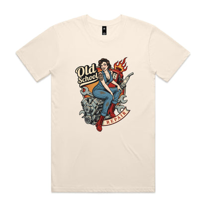 A vintage-style pin-up illustration printed on a white garment, showing a woman in blue overalls and red boots sitting on a motorcycle engine with wrenches, a gas pump, flames, and the words 'Old School' and 'REPAIR'.