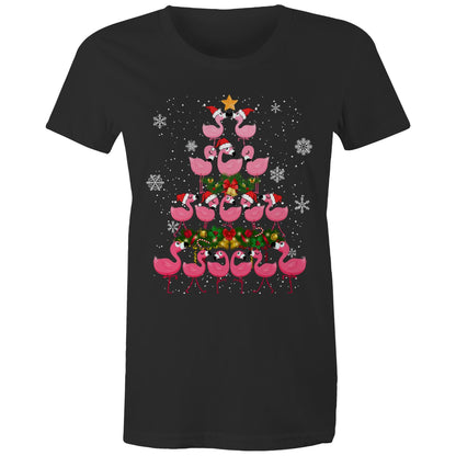A black t-shirt featuring a festive Christmas graphic of pink flamingos stacked in the shape of a Christmas tree, wearing red Santa hats, with a green wreath, gold bells, and white snowflakes on a black background.
