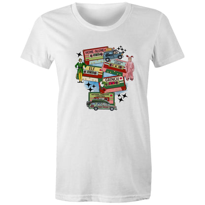 A graphic print on a light beige fabric featuring retro cassette tapes labeled 'Home Alone', 'Elf', 'The Grinch', 'National Lampoons Christmas', and 'A Christmas Story', with illustrated characters and black starbursts.