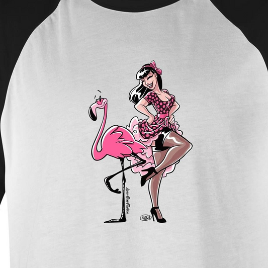 A white raglan baseball t-shirt featuring a retro-style graphic of a pin-up girl sitting on a pink flamingo. The shirt has black raglan sleeves and a black collar, with the graphic printed on the front.