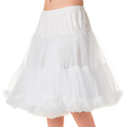A white tiered tulle petticoat skirt shown on a model from the waist down, paired with black high heels against a plain white background.
