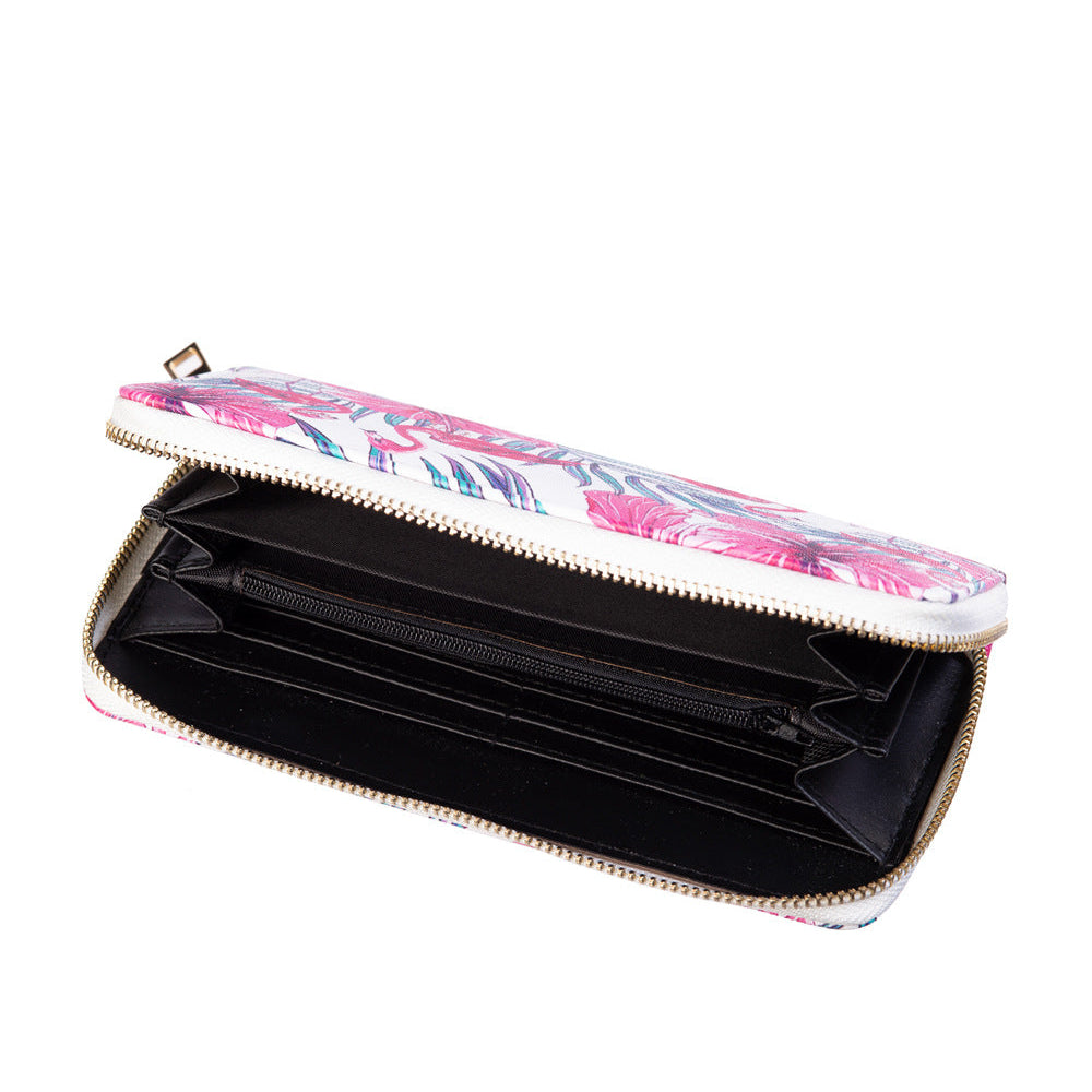 An open zip-around wallet with a pink floral patterned exterior, a black interior, and gold-tone metal zippers, shown on a plain white background.