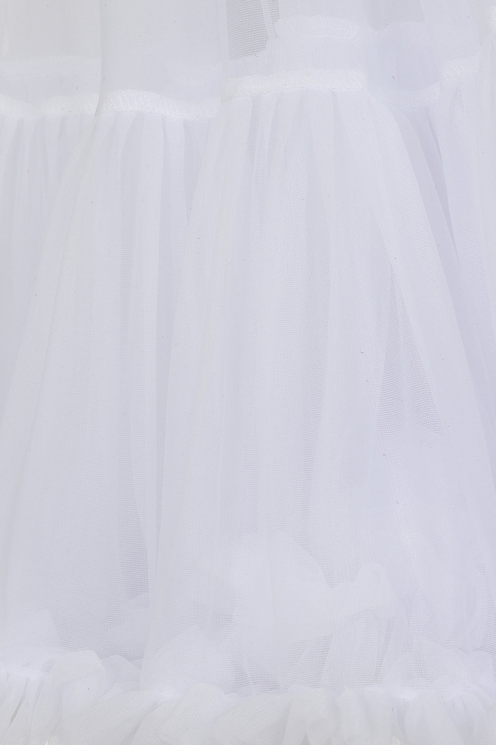 White ruffled tulle fabric close-up, showing layered sheer mesh and gathered texture.
