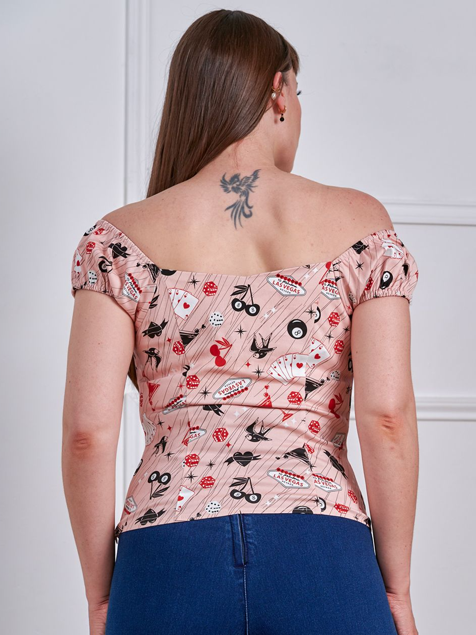 Woman wearing a floral off-shoulder top and blue jeans against a white background