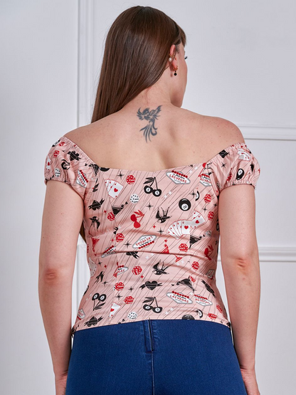Woman wearing a floral off-shoulder top and blue jeans against a white background