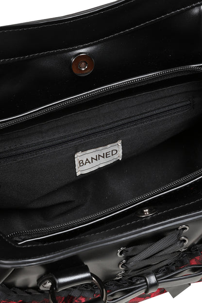 Close-up of the interior of a black handbag, showing a black fabric lining with a white label that reads 'BANNED'.