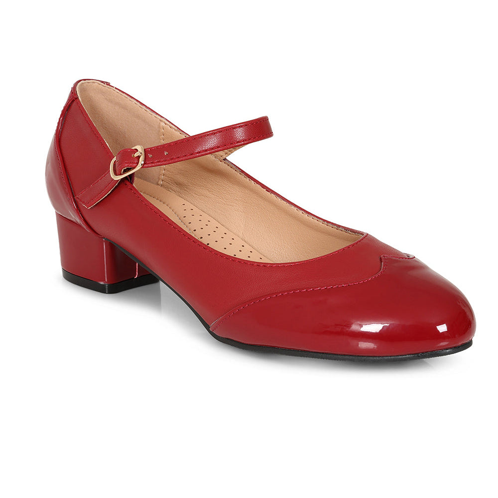 A red patent leather Mary Jane pump with a low block heel and a small gold buckle, shown on a white background with a black circular badge in the top right that reads 'ALSO AVAILABLE IN SIZE 42'.