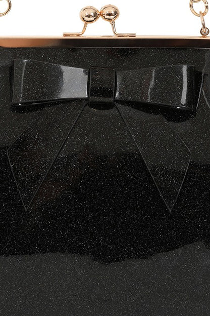 Black glittery clutch with a bow detail on a black background