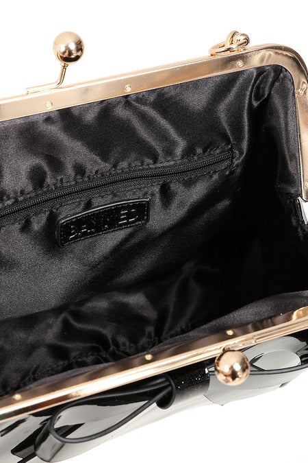 Black clutch bag with gold frame and hardware, featuring a brand label.