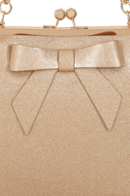 Gold glittery clutch bag with a large bow detail on a white background