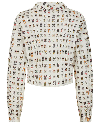 A cropped long-sleeve shirt with a white base and an all-over print of small cat faces in various colors, shown against a plain white background.
