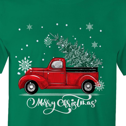 A green crewneck t-shirt featuring a festive graphic of a vintage red pickup truck carrying a Christmas tree, surrounded by white snowflakes and the text 'Merry Christmas' in white script.