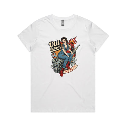 A vintage-style pin-up illustration printed on a white garment, showing a woman in blue overalls and red boots sitting on a motorcycle engine with wrenches, a gas pump, flames, and the words 'Old School' and 'REPAIR'.
