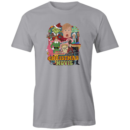 A close-up of a gray fabric garment featuring a large, colorful graphic print on the front. The print is a collage of characters and text from the movie 'Son of a Nutcracker: Are You Serious, Clerk?' including the Grinch in Santa hat, a blonde boy, a woman in a green dress, and bold text reading 'CHRISTMAS MOVIE'.