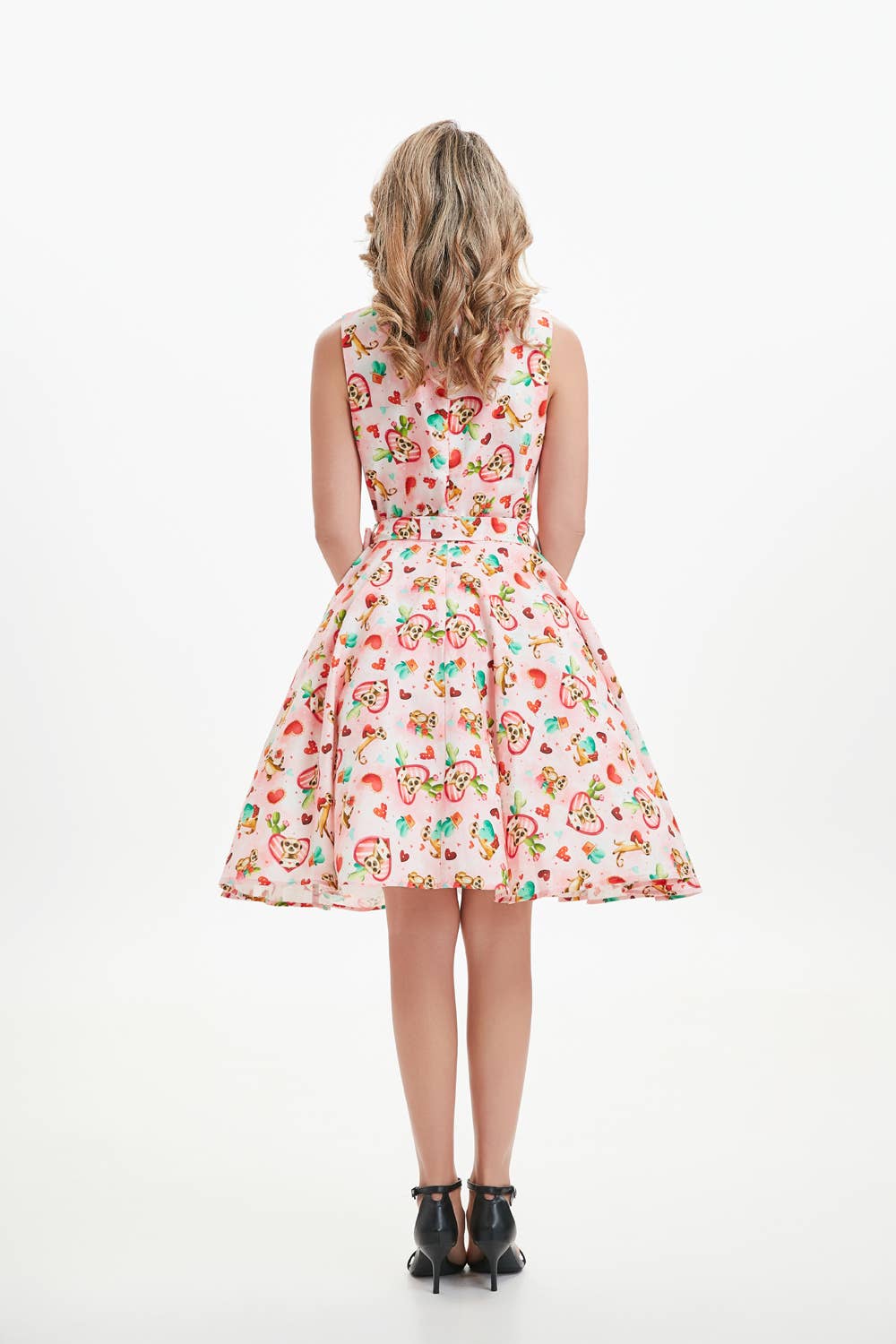 A woman wearing a knee-length sleeveless linen fit and flare dress with meerkat print pockets, a boat neckline, and an invisible zipper in the back. christmas dress xmas