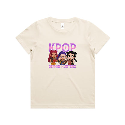 A graphic print featuring three chibi-style cartoon girls eating noodles, with the word 'K-POP' above them and 'DEMON HUNTERS' below, on a light cream background.