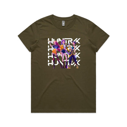 A close-up of a t-shirt featuring a graphic print of three stylized female characters in colorful outfits, overlaid with the word 'HUNTER' repeated vertically in bold white letters.