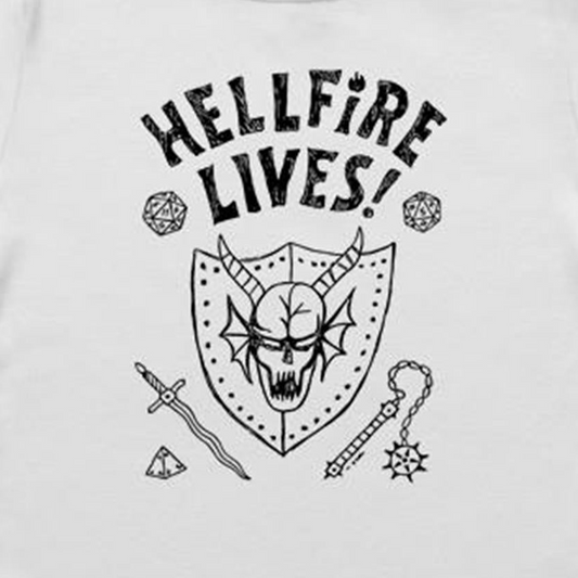 A close-up of a white garment, likely a t-shirt, featuring a black graphic print. The design displays the text 'HELLFIRE LIVES!' in a distressed, arched font above a horned skull inside a shield, surrounded by fantasy icons including dice, a sword, a key, and a gem.