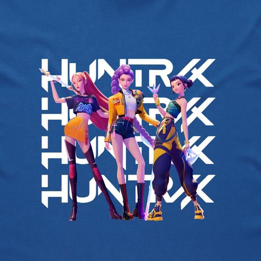 A blue graphic t-shirt featuring three stylized female anime characters standing in front of a large white repeating 'HUNTRX' logo. The shirt fabric is visible, and the graphic is printed in vibrant shades of purple, yellow, orange, and black.